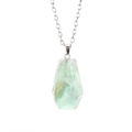 Macro shot of natural green fluorite coffin pendant on a thin silver chain - Fluorite