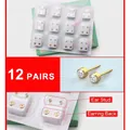 Macro detail of 12 pairs gold-plated stud earrings with sparkling cubic zirconia - Gold Color White Zircon (12 Pairs)