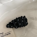 Nahaufnahme der gewellten schwarzen Haarklammer mit weißen Punkten und Hochglanz-Finish - Schwarze Träne