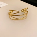 Detailansicht des mehrlagigen Crossover-Metallarmbands mit poliertem Goldfinish - Gold