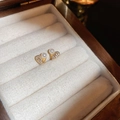 Nahaufnahme goldener Herzohrringe mit Zirkonia und Perlen in einer Samtschachtel - Zirkon Perle Herz Ohrstecker (HE12607) / Gold