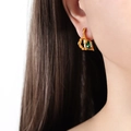 Artistic gold-tone earrings with irregular fluid design and rectangular green gemstone - Gold Green Glass Drill