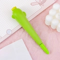 Cute green cartoon squeeze pen with yellow crown on pink desk with notebook - Cactus