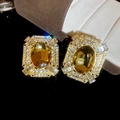 Primer plano de pendientes vintage dorados con gema amarilla y destellos de cristal - Oro-Amarillo Ámbar (Pin de Plata)