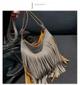 Close-up of a grey leather tassel bag with a vibrant orange lining and fine strap - Gray
