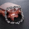 Bracelet tête de mort punk vintage pour hommes avec fini vieilli sur socle en bois sombre - Bracelet Tête de Mort