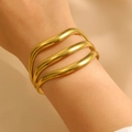 Vue détaillée du large bracelet manchette doré multicouche texturé vague sur un poignet - Bracelet Vague 3 Couches (H-74) / Or