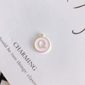 Detail view of round pink enamel pendant with gold metal letter Q for DIY jewelry making - Letter Q