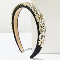 Macro view of crystal padded headband with sparkling clear stones and golden claw settings - White
