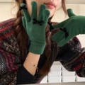 Close-up of green knitted gloves featuring elegant black bow decorations on fingers - One Size / Dark Green