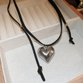 Close-up of polished silver heart pendant on adjustable black leather cord necklace - Black Leather Heart Necklace