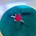 Detail of round cut ruby ring featuring six-prong setting on silver band with side stones - A6 Open Type / Red