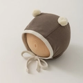 Close-up of baby earflap hat in coffee brown with cream pom-poms and adjustable straps - One Size (35-45cm) / Brown