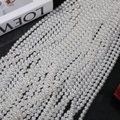 Close-up of polished white round 6-8mm imitation pearls on a black background - 3mm (Approx. 240pcs/Strand) / Australian White