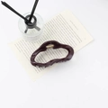 Pinza de pelo irregular brillante en color borgoña sobre fondo de libro abierto - Rojo Vino Oscuro