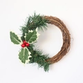 Détail d'une couronne de Noël avec baies rouges, feuilles de pin et base en vigne - Couronne de Vigne en Herbe Verte 15cm