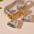 Détail de boucles d'oreilles cœur géométriques avec contraste métallique or et argent - Style Pendentif avec Tige en Argent / Style Coeur Mixte Or & Argent