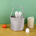 Close-up of gray velvet Easter basket with white bunny ears and pumpkin decor - Gray