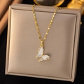 Elegante ciondolo a farfalla dorato con inserti in madreperla bianca e zirconi - Bianco Grigiastro