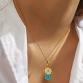 Close-up of a 18K gold Hamsa Hand pendant with blue enamel Evil Eye detail on a chain - Hamsa Hand (DJN017GL-SB)