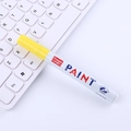 Yellow paint marker with 2.8mm tip and waterproof ink on white computer keyboard background - Yellow
