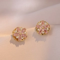 Elegante Ohrringe mit rosa Zirkonia-Blumen und Goldbasis auf luxuriöser Champagner-Seide - Rosa rotierende Blumenohrringe