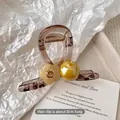 Macro shot of 8cm large amber floral hair claw clip with pearl and rhinestone accents - Medium Pale Yellow Flower Pearl Clip