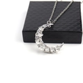Close-up of crescent moon pendant with silver wire-wrapped crystals on a black gift box - White Crystal