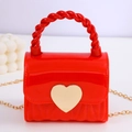 Mini red jelly handbag with twisted handle, gold heart clasp, and fine chain strap - Red