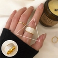 White enamel wavy band ring in gold finish on female hand with a modern minimalist style - JZ8827-1 Gold Wavy Edge White Enamel Ring