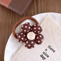 Detailed shot of brown floral hair tie with beige plush center on a white plate - Polka Dot Hair Tie