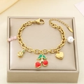 Detail of gold fruit charm bracelet with cherry, lemon, and pearl charms on a display stand - Cherry Pearl Lemon Style (KB203068-Z)