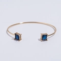Bracelet jonc doré ajustable avec deux pierres de zircon carrées bleues sur fond blanc - Bracelet en Verre Bleu / Bleu