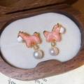 Makro-Detail des rosa Pony-Ohrrings mit Perle und Zirkon auf edlem Holz-Display - Silberstift-Rosa-Weiß (Echt Vergoldet)