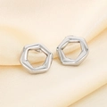 Elegant silver hexagonal hollow stud earrings on champagne silk fabric background - Hexagonal Hollow Style (KE114141-KFC)
