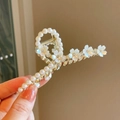 Detailed shot of golden flower hair claw clip with white pearls and rhinestones - Pearl Camellia
