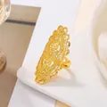 Detail of Dubai bridal gold hollow flower ring with intricate filigree on white ceramic - Long Oval Floral Filigree Style