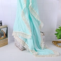 Close-up of light blue cotton muslin baby blanket with elegant cream tassel fringe edges - Mint Green