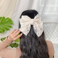 Elegant beige lace hair clip with a large bow and long ribbons shown on a model - 3-Layer Beige Lace Spring Clip