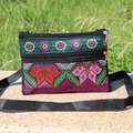 Detailed close-up of colorful floral embroidery and zippers on a black crossbody bag - Style 7