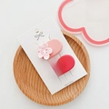 Detail of two cherry blossom hair clips in pink and red set on a white display card - D-017 Small Flower Pair