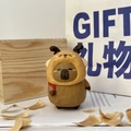 Hand-carved wooden capybara figurine wearing a brown hoodie with a gift bag setup - Christmas Hat Capybara