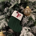 Green knit Christmas stocking with embroidered red letter F on a festive snowy tree - Green/Letter F