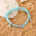 Blue braided rope anklet with silver sea turtle charm resting on beach sand with seashells - Antique Silver Blue Style (K-188)