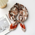 Silk square scarf with orange and brown paisley print shown tied in an elegant knot - Orange Red Beige Paisley