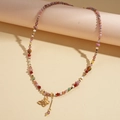 Close-up of colorful beaded necklace with a golden butterfly pendant and metal chain - Colored Butterfly Style (HN10273)