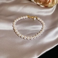 Dettaglio del bracciale di perle placcato oro 18k con zirconi su elegante seta champagne - Stile Perla Rosa 6mm / Rosa