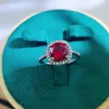 Macro shot of 2-carat ruby halo ring in silver band, placed in a luxury blue jewelry box - A3 Open Type / Red