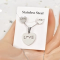 Close-up of heart-shaped stainless steel necklace and earrings with LOVE engraving - LOVE Letter Heart