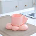 Pink ceramic mug set with cloud-shaped handle and matching saucer on a desk - Cloud Cup & Saucer - Pink